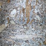La foto muestra unos cristales alargados de flogopita, los cuales en forma clara muestran la exfoliación paralela del mineral. En la parte superior de la foto, la flogopita está orientada en posición “norte-sur”, mostrando una coloración pardo-naranja. En la zona inferior, los mismos cristales, ahora orientados “este-oeste” muestran unos tonos mucho mas claros. (Autor: Vinoterapia)