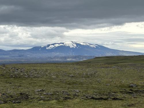 El Hekla es un estratovolcán situado al suroeste de Islandia, en la región de Suðurland. Tiene una altura de 1.491 metros sobre el nivel del mar y es uno de los más activos de la isla. La estructura del Hekla se considera intermedia entre la fisura de cráteres del tipo Laki, y el estratovolcán del tipo Vesubio. Se formó sobre la fisura de Heklugjá, de 5,5 km de largo, situada en una larga cresta volcánica. Los periodos de reposición de magma en el volcán han durado de 10 a 102 años. El depósito de magma que alimenta a Hekla se encuentra a una profundidad de entre 5 y 9 km. Durante los períodos no eruptivos la sismicidad es prácticamente nula, pero cuando se produce una erupción esta comienza sólo entre 30 y 80 minutos antes. Desde 1970, el volcán Hekla ha entrado en erupción aproximadamente cada 10 años, con una fase inicial siempre muy explosiva. Las cenizas y piroclastos expulsados en sus erupciones tienen un alto contenido en flúor. El tipo de roca que produce es una andesita basáltica, con un contenido de SiO2 superior al 54%, según la Clasificación TAS (Total Alkali Silica), siendo el único volcán islandés que genera lavas calco-alcalinas. En los periodos en los que no está en erupción suele estar cubierto de nieve.
La última erupción del volcán Hekla comenzó el 26 de febrero de 2000 y duró 12 días. Las fuentes de lava brotaron a través de una fisura de dirección SO-NE de 6,6 km de largo, al sur de la cumbre. Las cenizas alcanzaron una altura de 12 km en la fase inicial explosiva, para acabar con una fase efusiva tranquila de magma. (Autor: Antonio P. López)