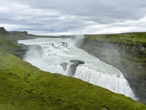 Gullfoss es una de las cascadas más imponentes y famosas de Islandia. Está situada en el cañón del río Hvitá, que nace en el lago Hvítárvatn procedente del glaciar Langjökull, en los Highlands (Tierras Altas), y pertenece al municipio de Bláskógabyggð.
Un kilómetro antes de la cascada Gullfoss (cascada ‘Dorada’), el río Hvitá gira bruscamente hacia el este cayendo en dos escalones curvados. El primero es de 11 metros y el siguiente salto es de 21 metros, precipitándose en una grieta de 70 metros de profundidad en total, que mide unos 20 metros de ancho y 2,5 kilómetros de largo, con un caudal medio de 140 metros cúbicos por segundo en verano.
Para comprobar el tamaño de Gullfoss solo hay que ver las personas situadas a la izquierda, a la altura del primer salto. (Autor: Antonio P. López)