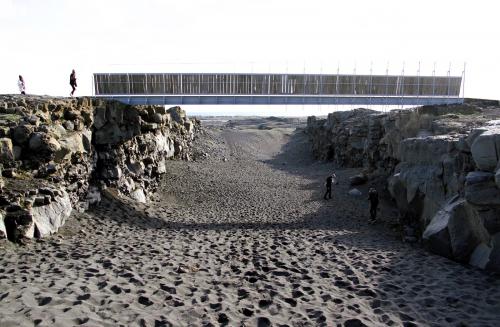 Para el turismo, la foto marca el límite entre las placas euroasiática y norteamericana, en la región de Suðurnes, en la península de Reykjanes. En realidad, es una fractura de tensión de dirección SO-NE, una de las muchas que hay en la zona, con sus flancos formados por flujos de lava pahoehoe, del Holoceno, y una fina arena negra basáltica de relleno en el centro. Algunas de las rocas más jóvenes de Islandia afloran en esta región, como se comprueba en las continuas erupciones fisurales de los últimos meses. (Autor: Antonio P. López)