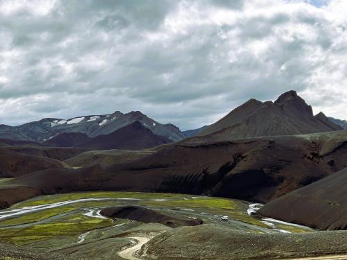 Panorámica del Landmannalaugar, en las Tierras Altas. En la parte inferior, la pista por la que hay que vadear el Kirkjufellsós, un afluente del Tungnaá por el que desagua el cercano lago Kirkjufellsvatn, afortunadamente con un caudal bajo. Siempre hay que estar atentos a las precipitaciones al adentrarse en esta área. Si ha llovido unos días antes, algunos ríos no pueden vadearse pues es muy peligroso ya que el caudal crece, va con mucha fuerza y puede arrastrar el vehículo. (Autor: Antonio P. López)