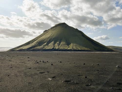 El volcán Mælifell está situado en la región de Suðurland, cerca del glaciar Mýrdalsjökull, que cubre la parte central de la caldera del volcán Katla, y sobre el ‘desierto negro de cenizas’ Mælifellssandur, al sur de Islandia. Se encuentra a unos 10 kilómetros al este de la caldera principal del Katla y se eleva a una altura de 764 metros sobre el nivel del mar, sobresaliendo unos 200 metros sobre la llanura.
Este estratovolcán se formó en el Pleistoceno superior, hace unos 10.000 años, y se le considera un cono secundario del Katla, lo que significa que se formó en un respiradero en los flancos del volcán principal, asociado a una erupción explosiva. 
Mælifell tiene un cono bien definido compuesto por una alternancia de capas de cenizas y lava basáltica rica en hierro. Las laderas del cono están completamente cubiertas de musgo de color verde que contrasta con el negro de las cenizas sobre el que se eleva el volcán. (Autor: Antonio P. López)