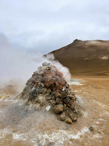 A mediados del siglo XX se hicieron varios sondeos para explorar las posibilidades energéticas de la zona, pero la tecnología de la época no era lo suficientemente avanzada y fracasó el intento. Dos grandes fumarolas, cubiertas con piedras y en forma de cono, son el recuerdo de este último intento. El pozo “H-10” comenzó a perforarse el 31 de julio 1953, alcanzando los 53 metros de profundidad. Tras desistir, se intentó taponar con una válvula, pero ésta no fue capaz de resistir la elevada acidez de los gases. En la foto, este último pozo. (Autor: Antonio P. López)