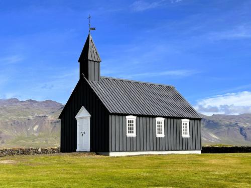 Búðakirkja es una pequeña iglesia de color negro aislada en los campos de lava de Búðahraun, cerca de la aldea Búðir (su playa está formada por minúsculos trozos de olivino de color verdoso amarillento), en el sur de la península de Snæfellsnes. Su construcción data de 1703. Fue reconstruida en 1848 y restaurada en 1987 por parte del Museo Nacional de Islandia. (Autor: Antonio P. López)