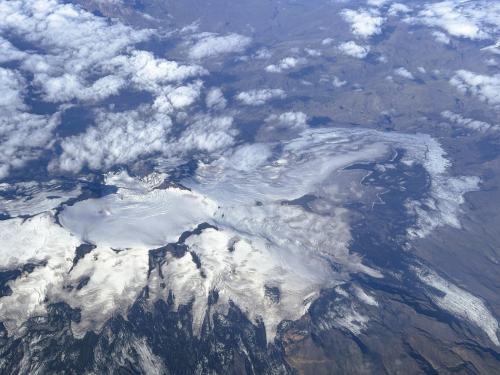 El Katla es uno de los volcanes más activos del sur de Islandia que forma, junto con el cañón Eldgjá, un sistema volcánico de fisuras. Está localizado bajo el glaciar Mýrdalsjökull. Tiene una altura de 1.490 metros, su caldera es de 10x14 km, con su eje largo en dirección NO-SE, y su profundidad alcanza los 750 metros. Las erupciones de este volcán subglacial son freatomagmáticas, producen altas columnas de cenizas y fuertes inundaciones debido al derretimiento de los glaciares. La mayor parte de la emisión de magma está formada por basaltos, riolitas y dacitas, y en menor cantidad por andesitas.
Se han documentado numerosas erupciones del volcán Katla, determinando que su periodo entre erupciones es de unos 40-80 años. Las erupciones desde el Holoceno (hace 10.600 años) se han caracterizado por ser de tres tipos: el primer tipo, erupciones explosivas basálticas dentro de la caldera, las cuales han ocurrido dos veces por siglo, siendo las más frecuentes; el segundo tipo, las erupciones explosivas silíceas en o cerca de la caldera, las cuales ocurren con menos frecuencia; y el tercer tipo, grandes erupciones de fisuras basálticas efusivas, produciendo volúmenes de 10 km cúbicos, las cuales han ocurrido en dos ocasiones durante el Holoceno. La última erupción explosiva tuvo lugar en 1918, arrojando 0,7 km cúbicos de material efusivo y provocando graves inundaciones.
En la imagen, vista del volcán Katla desde el aire. (Autor: Antonio P. López)