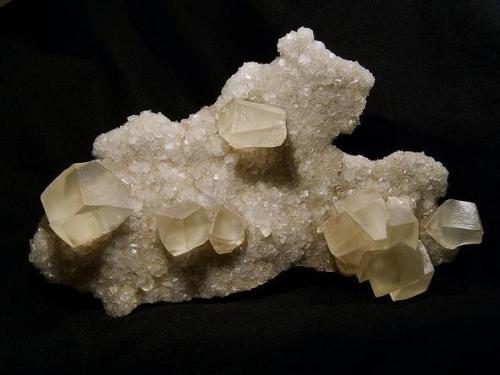 Calcite + stilbite
Biod a’ Mhurain, Duirinish, Isle of Skye, Scotland, UK
The plate measures 22 cm x 13 cm

Very large plate covered on both sides with simple calcite rhombs to 5mm, on a layer of micro stilbite crystals (which are much more exposed on the back of the specimen). Several groups of large pale yellow interpenetrant calcite rhombs are perched aesthetically on the specimen. The plate measures 22cm x 13cm. Self-collected, in the company of Dave Green, 1997 from Biod a’ Mhurain, Duirinish, Isle of Skye. (Author: Mike Wood)