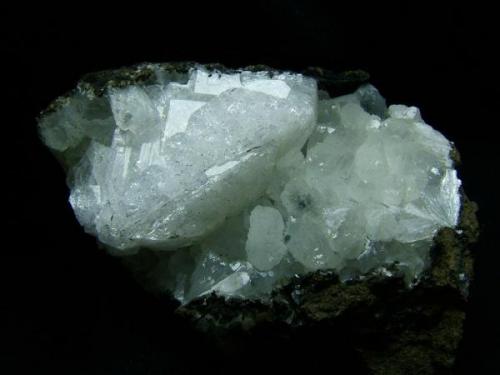 Chabazite + stilbite
Oisgill Bay, Duirinish, Isle of Skye, Scotland, UK
Crystal of chabazite 3 cm wide

Very large and fresh twinned crystal of chabazite 3cm wide in a vug with small fresh ’cauliflower’ (ie flat-topped) stilbites. Self-collected 1996 from Oisgill Bay, Duirinish, Isle of Skye. (Author: Mike Wood)