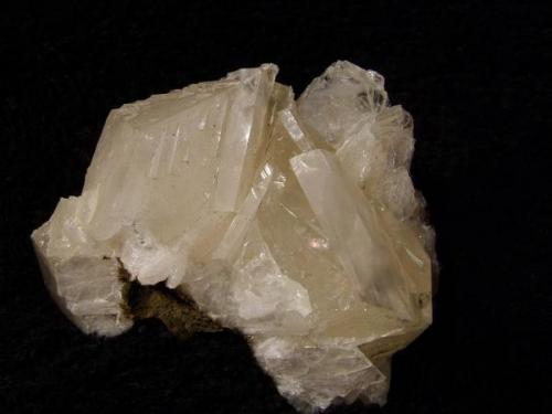 Calcite + stilbite. Basically a rhombohedral habit of transparent calcite, but elongated, into thin crystals, on a bed of stilbite. Specimen measures 55mm wide x 40mm high x 30mm deep. Self-collected 1994 from Sgurr nam Boc, Minginish, Isle of Skye. (Author: Mike Wood)