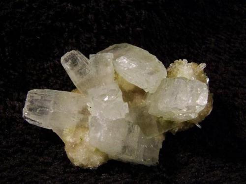 Apophyllite + stilbite + thomsonite. Lustrous transparent apophyllite crystals, with curved pinacoidal terminations, on a bed of thomsonite with associated small stilbites. Specimen measures 42mm x 30mm x 20mm. Self-collected 2010 from Moonen Bay, Isle of Skye, Scotland. (Author: Mike Wood)