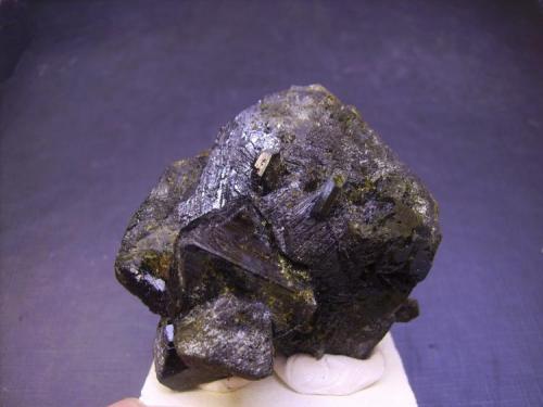 Epidota
Raywoo Mine, Quetta, Balochistán, Pakistán
5,5 x 4 x 5 cm.
Esta segunda pieza muestra el otro hábito -pseudo-octaédrico- con varios cristales más pequeños interpenetrantes. Sin apenas recubrimiento de pequeños cristales amarillos por la parte delantera. Parecen bipirámides rematadas por un pinacoide que no se aprecia bien en esta foto. En este caso aparecen estrías en las caras paralelas al eje b. Como dato curioso, relacionado posiblemente con la cantidad de Fe que contienen, es su elevado peso específico. (Autor: Antonio Alcaide)