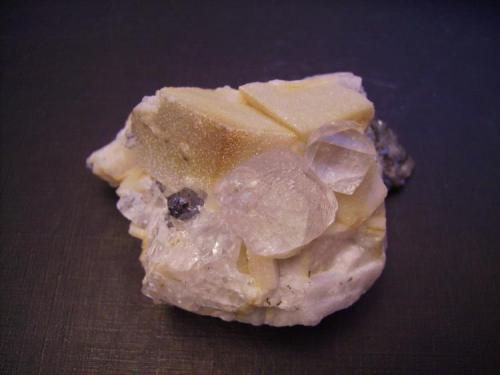 Fluorita, galena, calcita
Naica, Mun. de Saucillo, Chihuahua, Méjico
6,5 x 4,5 cm.
Delante de dos romboedros de calcita con una recristalización de cuarzo, dos cristales complejos de fluorita. El mayor mide 2 cm. arista y parece más bien un grupo de cristales que han crecido juntos. (Autor: Antonio Alcaide)