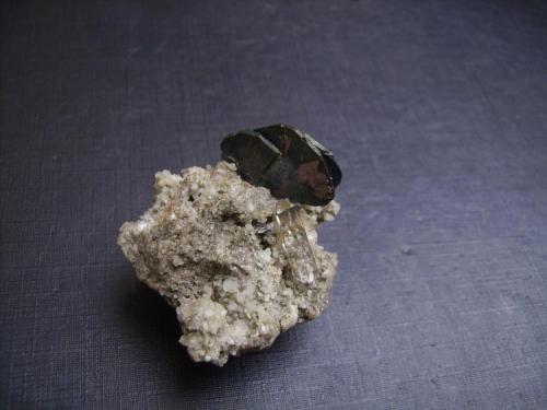 Hematites y rutilo
Val Curnera, Tavetsch, Graubunden, Suiza
4 x 3,5 x 3,5 cm.
Pieza de localidad clásica alpina. El cristal de hematites mide 2 cm y presenta rutilo epitáctico, que ha crecido orientado según el hematites. Además, un pequeño cuarzo biterminado y pequeños escalenoedros de calcita. De colección antigua (circa 1910), con bonita etiqueta autógrafa. (Autor: Antonio Alcaide)