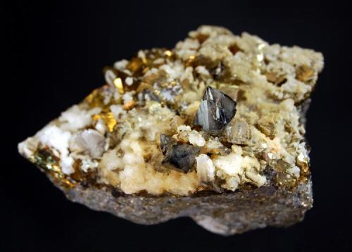 Scheelite
Baia Sprie Mine,
4.1 x 6.3 cm.
Lustrous, smoky-gray, scheelite crystals with small laminar calcite crystals and brassy chalcopyrites. Mined in summer 2002. (Author: crosstimber)