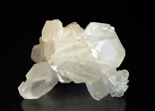 Calcite
First Sovietskiy Mine, Dal’negorsk, Primorskiy Kray, Russia
4.0 x 5.5 cm.
An intergrown group of colorless tabular hexagonal crystals associated with a small piece of green fluorite. (Author: crosstimber)