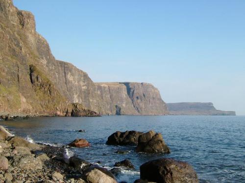 Moonen Bay, Isle of Skye, Scotland, UK
Looking across Moonen Bay (southward). The cliffs are very steep, often with rockfall, especially when it rains. The tide cuts off access to most of the ’beach’ at the foot of the cliffs. The cliffs in the distance (Ramasaig Cliff) reach over 700’ high (230m).
Photo taken April 2005 (Author: Mike Wood)