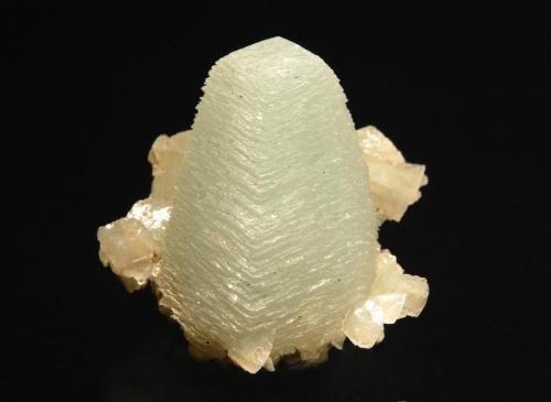 Calcite
Vambori, Aurangabad District, Maharashtra, India
4.5 x 5.0 cm.
Pale green scalenohedral calcite crystal composed of multiple stacked rhombs, with small calcite rhombs around the base. Recovered during a well dig in 2005. (Author: crosstimber)