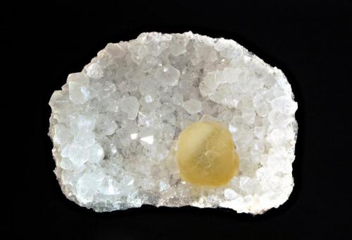 Fluorite
Mahodari Quarry, Nasik, Maharashtra, India
6.5 x 9.0 cm.
A translucent, yellow sphere of fluorite resting on a concave bed of quartz crystals. (Author: crosstimber)