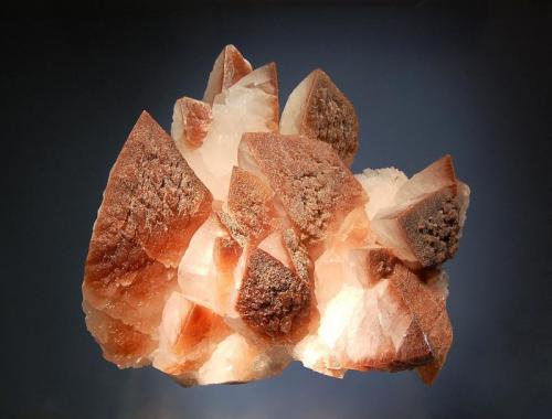 Calcite
Leiping Mine, Guiyang Co., Chenzhou Pref,, Hunan Prov., China
11.0 x 15.0 cm.
Milky white Calcite crystals terminated by a steep pyramid and tinged reddish brown with iron oxides. (Author: crosstimber)