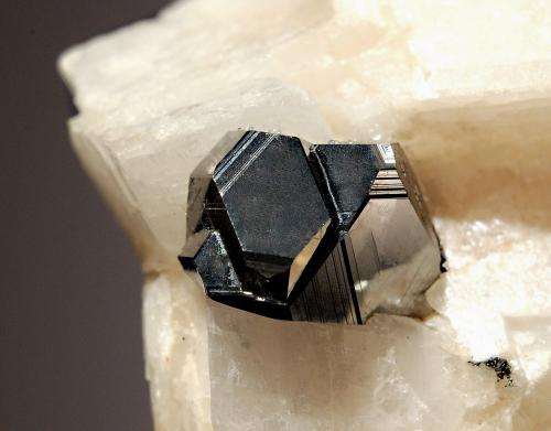 Carrollite
Kamoya South II Mine, Kambove Dist., Katanga Prov., DR Congo
4,2 x 5.3 cm.
Lustrous, sharp metallic carrollite crystal measuring 1.2 cm. frozen in a calcite matrix. Found in 2001 and acquired from Gilbert Gauthier. (Author: crosstimber)