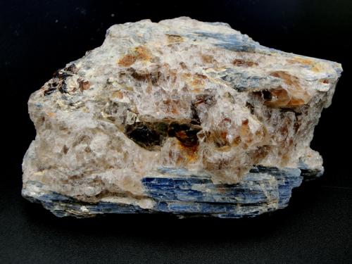 Cianita
Barra Salinas, Coronel Murta, Jequitinhonha Valley, Minas Gerais, Brasil.
Ancho de imagen 11 cm.
La cianita azul se acompaña de cuarzo, moscovita y algún otro mineral que no he sido capaz de identificar. Pueden verse dos grandes cristales de moscovita en la zona central de la imagen. (Autor: María Jesús M.)