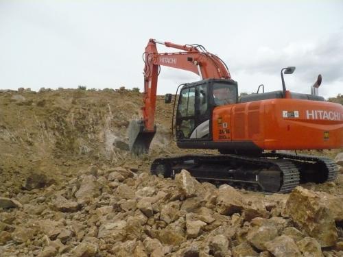 Foster is a genius with the trackhoe.  He not only scrapes the walls of the pits, he also removes a lot of the rock rubble at the foot of the walls and he opens access to the walls so that it is easy to walk up to them. (Author: John S. White)