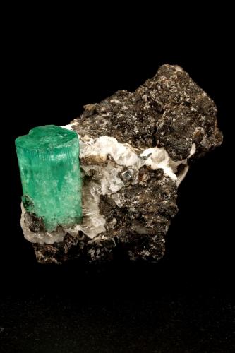 Beryl (variety emerald), Calcite, Parisite, Aragonite(?)<br />Muzo (distrito minero), Cinturón Esmeraldífero Occidental, Departamento Boyacá, Colombia<br />38x40x31mm, xl=15x10mm<br /> (Author: Fiebre Verde)