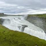 Gullfoss es una de las cascadas más imponentes y famosas de Islandia. Está situada en el cañón del río Hvitá, que nace en el lago Hvítárvatn procedente del glaciar Langjökull, en los Highlands (Tierras Altas), y pertenece al municipio de Bláskógabyggð.
Un kilómetro antes de la cascada Gullfoss (cascada ‘Dorada’), el río Hvitá gira bruscamente hacia el este cayendo en dos escalones curvados. El primero es de 11 metros y el siguiente salto es de 21 metros, precipitándose en una grieta de 70 metros de profundidad en total, que mide unos 20 metros de ancho y 2,5 kilómetros de largo, con un caudal medio de 140 metros cúbicos por segundo en verano.
Para comprobar el tamaño de Gullfoss solo hay que ver las personas situadas a la izquierda, a la altura del primer salto. (Autor: Antonio P. López)