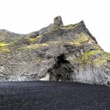 Los procesos volcánicos que formaron el acantilado subglacial son evidentes en la playa de Reynisfjara. La erosión de las olas ha dejado al descubierto un detallado resumen de su génesis. Lo más destacado son las columnas basálticas de forma poligonal que aparecen en la base del acantilado. Una intrusión horizontal de magma basáltico que fluye entre 1.200-1.300°C se enfría gradualmente hasta alcanzar unos 800°C, a partir de ahí comienza un lento proceso de solidificación. Durante el enfriamiento, el basalto se contrae y disminuye su volumen provocando que se formen una serie de fracturas o diaclasas más o menos verticales, denominadas disyunción columnar, formando las típicas columnas de basalto. El tamaño de estas columnas poligonales, generalmente de cinco o seis lados, viene determinado por la velocidad de enfriamiento del magma, siendo las mayores las formadas por enfriamientos más lentos. 
En el centro de la imagen hay una cueva, llamada Hálsanefshellir, producto de la erosión provocada por las olas en las columnas de basalto. (Autor: Antonio P. López)