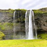 Las aguas de la cascada Seljalandsfoss proceden del río Seljalandsá que tiene su origen en el glaciar Eyjafjallajökull. El agua cae desde unos 60 metros de altura de un antiguo acantilado de rocas volcánicas que estaba en la línea de costa del océano Atlántico hace varios miles de años. En la actualidad marca el límite entre las Tierras Altas (Highlands) y el resto del país. (Autor: Antonio P. López)