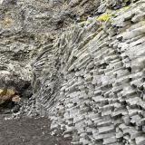 A la derecha, grupo de finas columnas de basalto. A la izquierda y de color ocre, ‘pillow lavas’ o lavas almohadilladas, formadas cuando el magma es expulsado en una zona con agua. Debido a la enorme diferencia de temperatura entre la lava y el agua, la superficie de la lengua emergente se enfría muy rápido, formando una corteza. La lengua continúa creciendo e hinchándose con más lava, formando un lóbulo, hasta que la presión del magma rompe la corteza y comienza de nuevo el proceso con la formación de otro lóbulo. En la parte superior, hialoclastitas y tobas. (Autor: Antonio P. López)