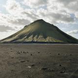 El volcán Mælifell está situado en la región de Suðurland, cerca del glaciar Mýrdalsjökull, que cubre la parte central de la caldera del volcán Katla, y sobre el ‘desierto negro de cenizas’ Mælifellssandur, al sur de Islandia. Se encuentra a unos 10 kilómetros al este de la caldera principal del Katla y se eleva a una altura de 764 metros sobre el nivel del mar, sobresaliendo unos 200 metros sobre la llanura.
Este estratovolcán se formó en el Pleistoceno superior, hace unos 10.000 años, y se le considera un cono secundario del Katla, lo que significa que se formó en un respiradero en los flancos del volcán principal, asociado a una erupción explosiva. 
Mælifell tiene un cono bien definido compuesto por una alternancia de capas de cenizas y lava basáltica rica en hierro. Las laderas del cono están completamente cubiertas de musgo de color verde que contrasta con el negro de las cenizas sobre el que se eleva el volcán. (Autor: Antonio P. López)