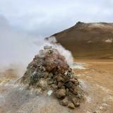 A mediados del siglo XX se hicieron varios sondeos para explorar las posibilidades energéticas de la zona, pero la tecnología de la época no era lo suficientemente avanzada y fracasó el intento. Dos grandes fumarolas, cubiertas con piedras y en forma de cono, son el recuerdo de este último intento. El pozo “H-10” comenzó a perforarse el 31 de julio 1953, alcanzando los 53 metros de profundidad. Tras desistir, se intentó taponar con una válvula, pero ésta no fue capaz de resistir la elevada acidez de los gases. En la foto, este último pozo. (Autor: Antonio P. López)