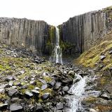 Stuðlafoss es una espectacular cascada sobre columnas basálticas que se encuentra muy cerca del cañón Stuðlagil, en el valle Jökuldalur, al este de Islandia. Las columnas de basalto están perfectamente alineadas y en posición vertical, con una altura de más de 20 metros. La roca fundida expulsada a la superficie comienza a enfriarse expuesta a las condiciones ambientales. Este enfriamiento provoca que se contraiga y se desarrollen fisuras que se extienden desde la superficie hacia el interior del flujo. Estas fisuras se forman perpendicularmente a la superficie de enfriamiento y dan como resultado la característica forma poligonal de las columnas de basalto. (Autor: Antonio P. López)