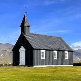 Búðakirkja es una pequeña iglesia de color negro aislada en los campos de lava de Búðahraun, cerca de la aldea Búðir (su playa está formada por minúsculos trozos de olivino de color verdoso amarillento), en el sur de la península de Snæfellsnes. Su construcción data de 1703. Fue reconstruida en 1848 y restaurada en 1987 por parte del Museo Nacional de Islandia. (Autor: Antonio P. López)