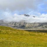 “In Sneffels Yoculis craterem kem delibat umbra Scartaris Julii intra calendas descende, audas viator, et terrestre centrum attinges. Kod feci” (Desciende al cráter del Yocul de Sneffels que la sombra del Scartaris acaricia antes de las calendas de Julio, audaz viajero, y llegarás al centro de la tierra, como he llegado yo). Esta es la traducción al latín (y al castellano) del texto de origen rúnico que ocultaba un criptograma del alquimista islandés Arne Saknussemm en el libro de Julio Verne “Viaje al centro de la Tierra”, publicado en 1864, en el que se revela cómo llegar al centro de la Tierra descendiendo por el volcán Snæfell.
Snæfellsjökull es un estratovolcán, cubierto por el glaciar del mismo nombre, situado en el extremo oeste de la península de Snæfellsnes, sobre la placa norteamericana. La zona de ruptura de Snæfellsnes se extendió activamente hasta hace unos 6 millones de años, cuando el límite de placas se desplazó hacia el este. Con unos 700.000 años de antigüedad, es uno de los cuatro sistemas volcánicos del cinturón volcánico de Snæfellsnes. La última erupción explosiva se produjo hace más de 1.100 años y arrojó 0,11 kilómetros cúbicos de material volcánico, formando el cráter actual que se eleva hasta los 1.446 metros sobre el nivel del mar. Posee numerosos conos piroclásticos laterales. Los conos de la parte superior de los flancos están formados por rocas de composición intermedia a félsica, mientras que los de la parte inferior son basálticos. (Autor: Antonio P. López)