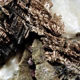 Close up of above specimen showing the herringbone pattern of the silver. Several small purple fluorites are visible in bottom center of the photo. (Author: crosstimber)