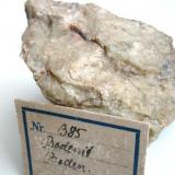 Brownish bodenite, a Mg-bearing variety of allanite-(Y) in oligoclase from Boden limestone quarry, Marienberg, Saxony. 1 cm crystal. With 1926 label. (Author: Andreas Gerstenberg)
